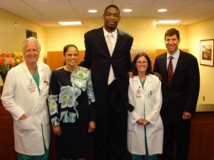  NBA star Dikembe Mutombo visited our offices to meet with his fellow Hoya Suzie Wollard to talk about his new hospital in his native Democratic Republic of Congo. Joining him in this photo are (l-r) Dr. Stieg; Mireille Kanda, MD, MPH, senior medical advisor to the Dikembe Mutombo Foundation; and Suzie her husband, Scott.