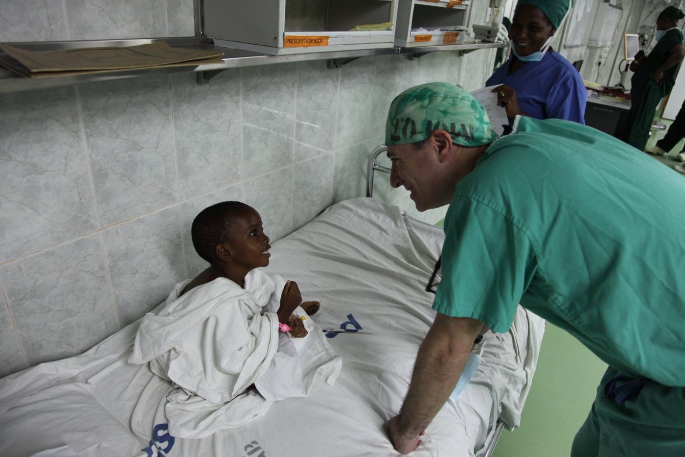 Dr. Greenfield charms a young patient (and vice versa), Tanzania 2014