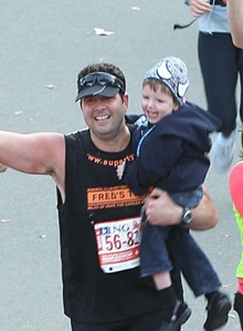 Lou Campell carries Ty across the finish line of the NY Marathon, 2011